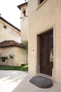 a building with a wooden door in a yard at Via Paradiso 32 in Feltre