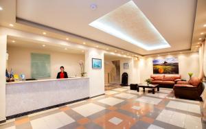 a woman is standing at a reception desk in a lobby at Green Bay in Limenaria +37 photos