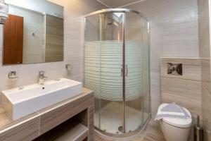 a bathroom with a glass shower and a sink at Green Bay in Limenaria
