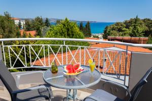 a table on a balcony with a bowl of fruit on it at Green Bay in Limenaria