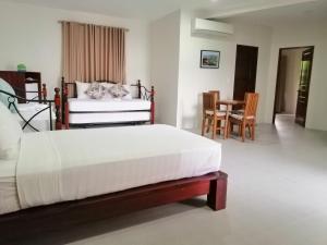 a bedroom with a bed and a table and chairs at Nirvana Resort Puerto Galera in Puerto Galera