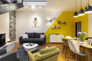 a living room with a couch and a table at La Sonate by Cocoonr in Rennes