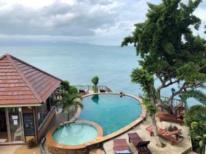 an image of a swimming pool with the ocean in the background at Petit Suncliff Resort in Haad Rin