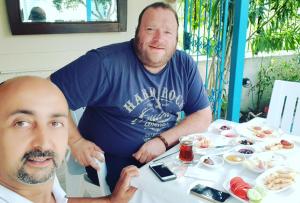 Zwei Männer sitzen an einem Tisch mit Essen drauf. in der Unterkunft Akmonya Pansiyon in Eriklice