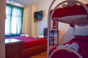 a bedroom with two bunk beds and a desk and a kitchen at Agrilao in Scalea