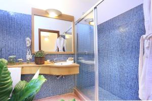a bathroom with a shower, sink, and mirror at Alghero Resort Country Hotel & Spa in Alghero