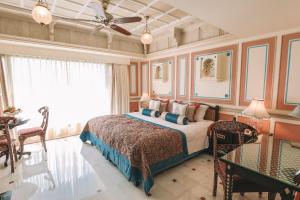a bedroom with a bed and a table and chairs at Taj Lake Palace Udaipur in Udaipur +102 photos