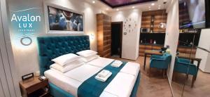 Un dormitorio con una cama grande con cabecero azul. en Avalon Lux Studio Apartment, en Novi Sad