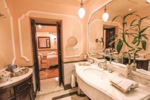 a bathroom with a sink and a large mirror at Taj Lake Palace Udaipur in Udaipur