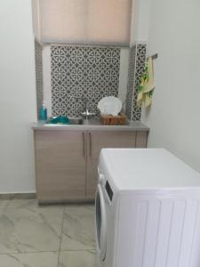 una cucina con lavandino e lavatrice di Great views apartment. a Limassol