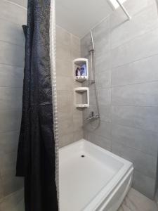 La salle de bains est pourvue d'une douche et d'une baignoire blanche. dans l'établissement Great views apartment., à Limassol