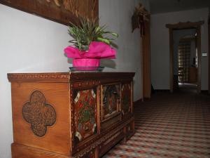 une armoire en bois avec une fleur rose en haut dans l'établissement Residence Rottonara, à Corvara in Badia
