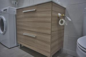 a bathroom with a wooden cabinet next to a toilet at GS Latina in Madrid