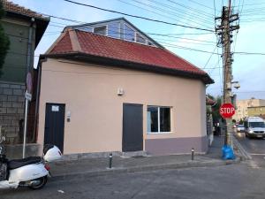 ein kleines Haus mit einem Roller neben einem Stoppschild in der Unterkunft Gruia Lofts in Cluj-Napoca