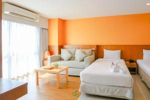 a bedroom with two beds and a cat sitting on a bed at Crystal Jade Hotel in Rayong