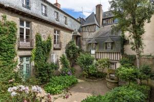 un patio de una casa antigua con plantas y flores en La Sonate by Cocoonr, en Rennes