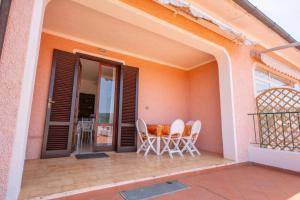 patio z krzesłami i stołem na balkonie w obiekcie Le Saline w mieście Portoferraio
