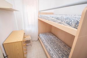 ポルトフェッラーイオにあるLe Salineの二段ベッド2台、デスクが備わる小さな客室です。