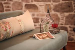 a table with a pillow and a glass of wine at Hotel Sobe in Ayvalık