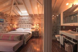 a bedroom with two beds and a bathroom with a sink at Hotel Sobe in Ayvalık