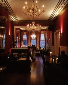 um bar com um lustre e pessoas sentadas numa sala em Hostel Lybeer Bruges em Bruges