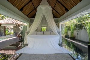 a bedroom with a bed with a canopy at Kayumanis Nusa Dua Private Villa & Spa in Nusa Dua