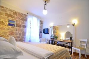 a bedroom with a bed and a stone wall at Hotel Sobe in Ayvalık