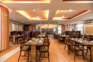un ristorante con tavoli e sedie in una stanza di Airport Hotel a Kathmandu