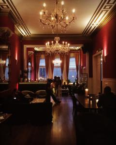 a bar with a chandelier and people sitting in a room at Hostel Lybeer Private Rooms just for two! in Bruges