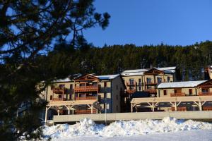 ein Resortgebäude mit Schnee davor in der Unterkunft Vacancéole - Les Chalets de l'Isard in Les Angles