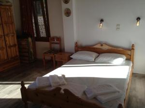 a bedroom with a wooden bed with towels on it at Mpaliaka Myrsini in Mythimna
