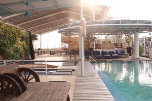 einen Pool mit einem Tisch und Bänken neben einem Pool in der Unterkunft RedDoorz Premium near Bandung Station in Bandung