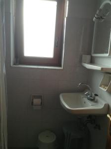 a small bathroom with a sink and a window at Mpaliaka Myrsini in Mythimna