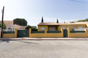 una casa amarilla con una valla en una calle en INNOUTHOME Villa Tord, en L'Ametlla de Mar