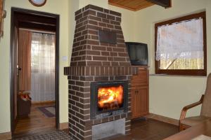 a brick fireplace in a living room with a tv at Domek w Sajenku in Augustów
