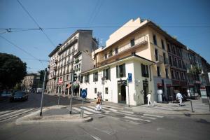 una intersección de una calle con un edificio blanco en Be Mate Via Tivoli, en Milán