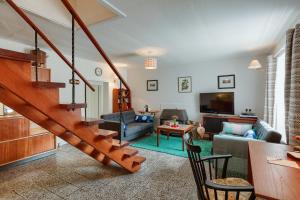 a living room with a staircase and a couch at Enchanting,rustic, Dundurn Mill with stunning views and private river in Comrie