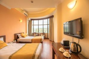 Habitación de hotel con 2 camas y TV de pantalla plana. en Airport Hotel en Katmandú