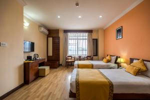 a hotel room with two beds and a television at Airport Hotel in Kathmandu