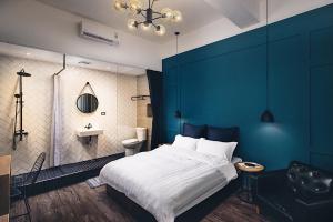 台南的住宿－蓋茨比公寓，一间卧室设有一张大床和蓝色的墙壁
