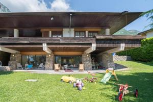 ein Haus mit Spielzeug im Gras davor in der Unterkunft Villa Mazzucco in Ponte nellʼAlpi