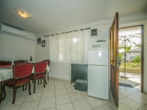 eine Küche mit einem Tisch und einem weißen Kühlschrank in der Unterkunft Apartman Ana in Lovran
