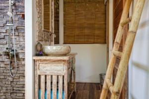 Un baño con un lavabo sobre una mesa de madera. en United Colors of Gili, en Gili Meno 67 fotos más