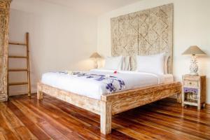 Un dormitorio con una cama grande y suelo de madera. en United Colors of Gili, en Gili Meno