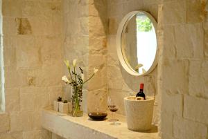 a bathroom with a mirror and a bottle of wine at Via Paradiso 32 in Feltre