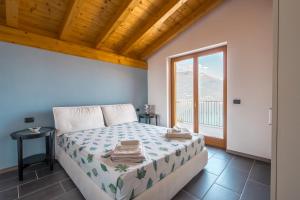 a bedroom with a bed and a large window at Residence Primavera in Bellano