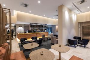 a living room filled with furniture and a tv at Deco Hotel Canberra in Canberra