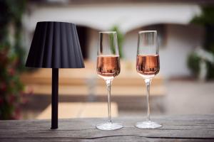 dwie szklanki wina obok lampy na stole w obiekcie Weingut Burger w mieście Kalladorf