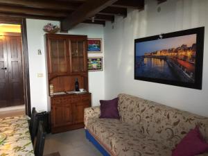 a living room with a couch and a tv on the wall at Tolomei House Holidays Sea View in Siracusa