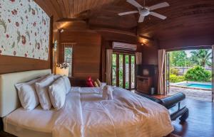 a bedroom with a large bed with a ceiling fan at GajaPuri Resort Koh Chang in Ko Chang